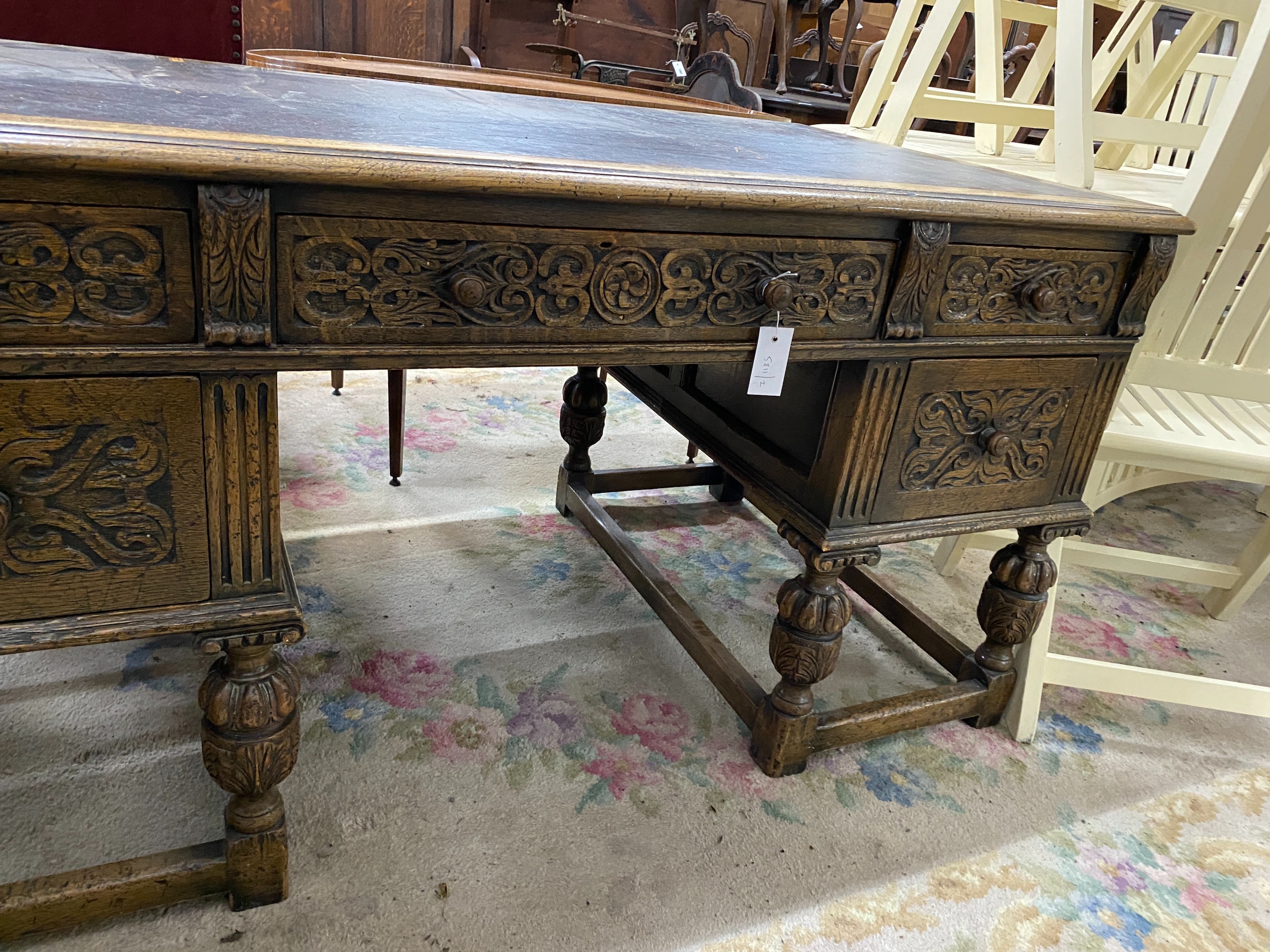 A 1920's Jacobean revival carved oak five drawer kneehole desk, length 144cm, depth 83cm, height 75cm